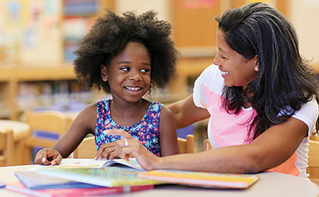 Rogerwene Gifford helps a student with literacy skills.