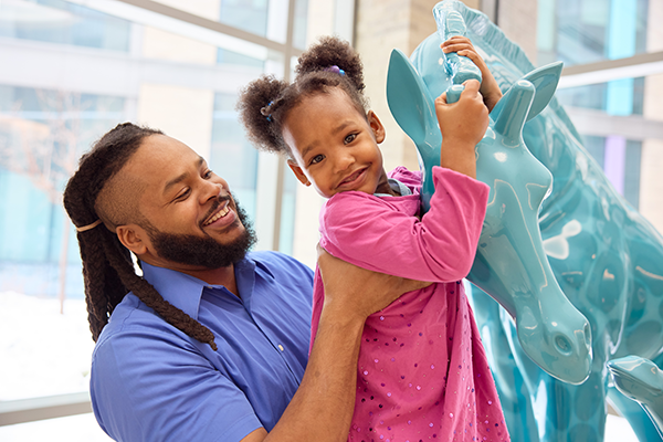 Dad and daughter smile.