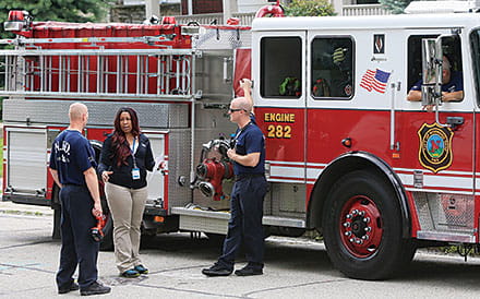 Dawn Gardner, CCIC injury coordinator, works with the Norwood Fire Department to install safety equipment. 