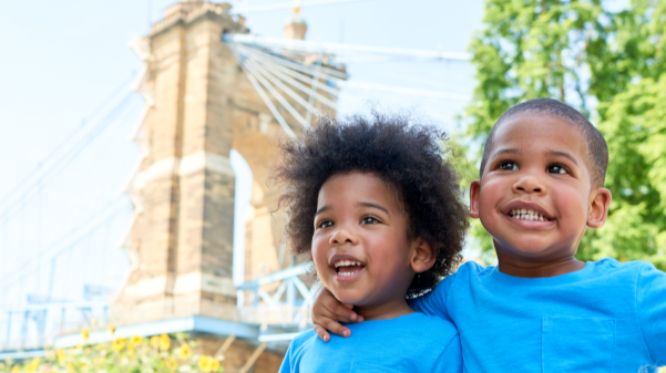 Two brothers smile and hug in downtown Cincinnati along the river.