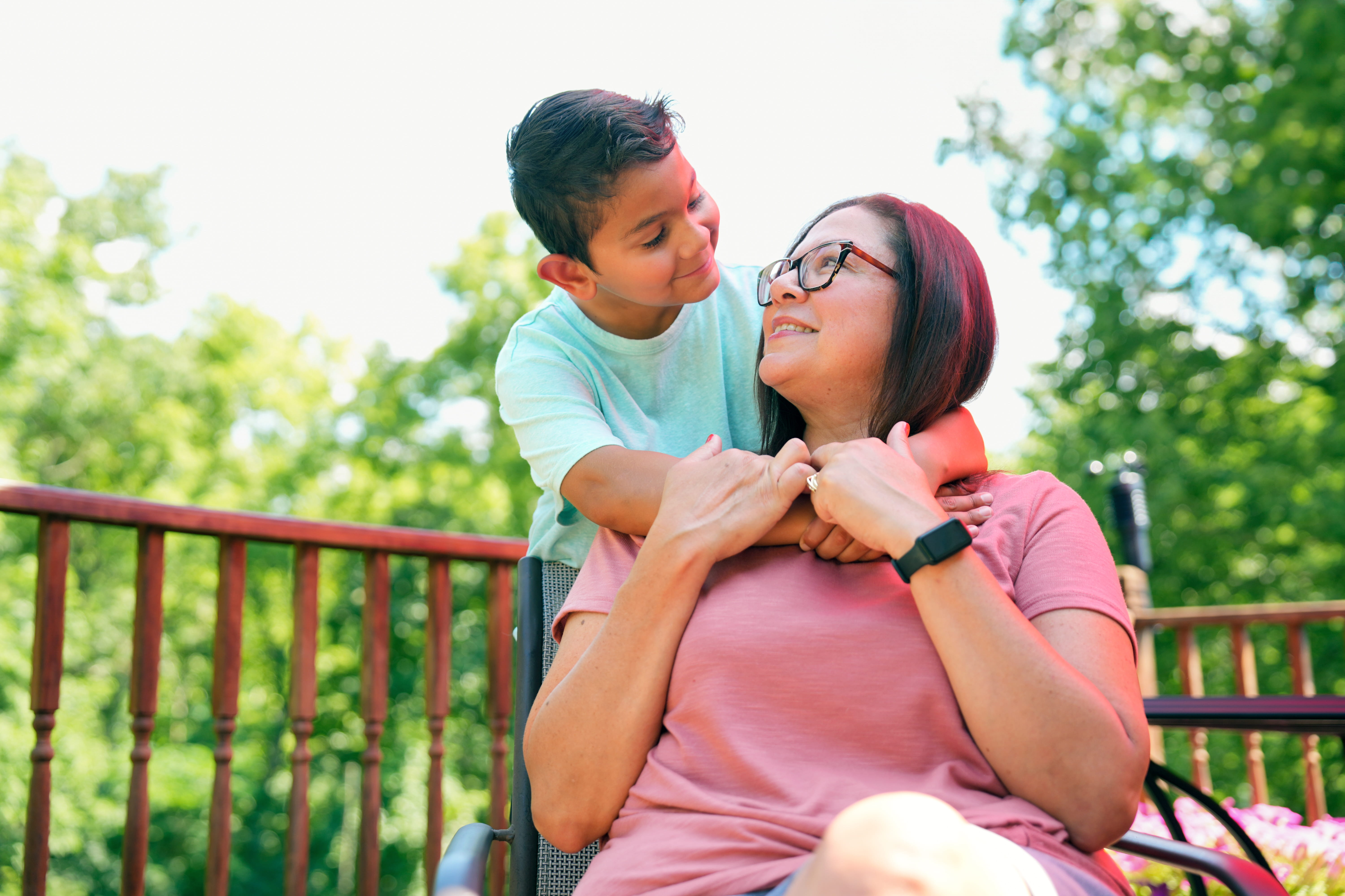 Caleb and his mom outside smiling at each other.