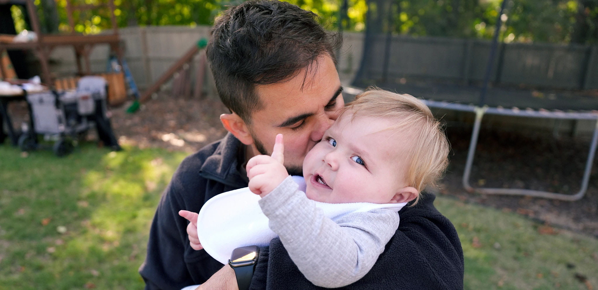 A father kisses his son on the cheek.