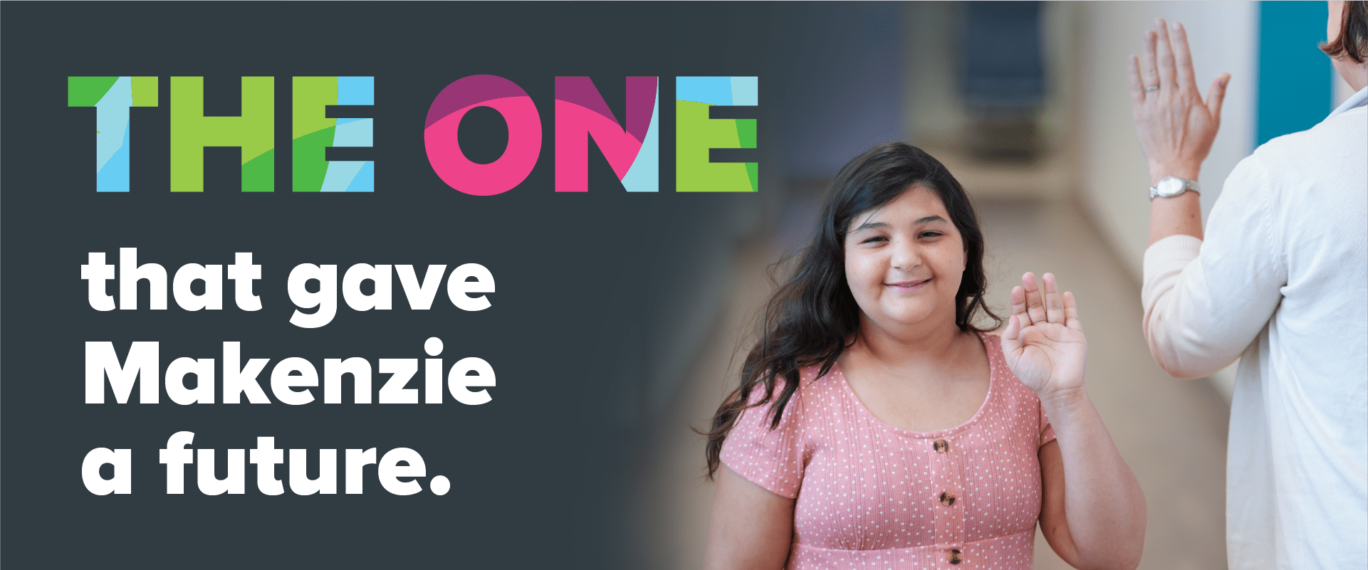 A young girl and her doctor pass in the halway and wave hi to each other.