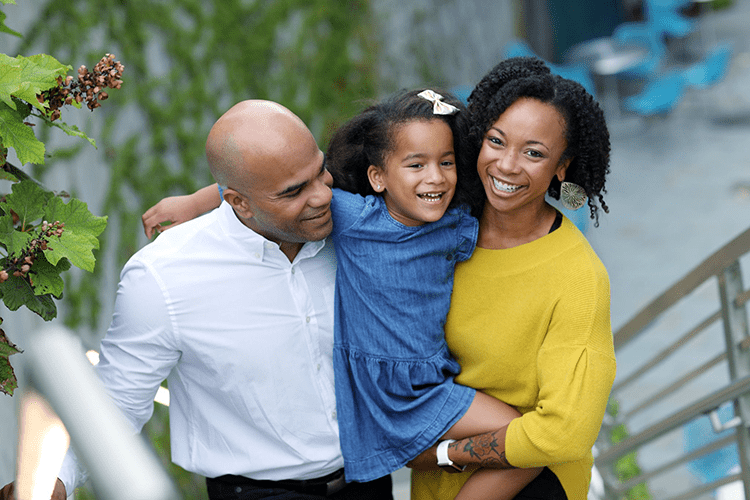 An image of a family outside smiling.
