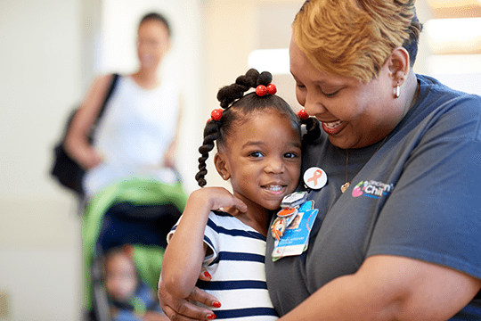A Cincinnati Children's employee embracing a pediatric patient.