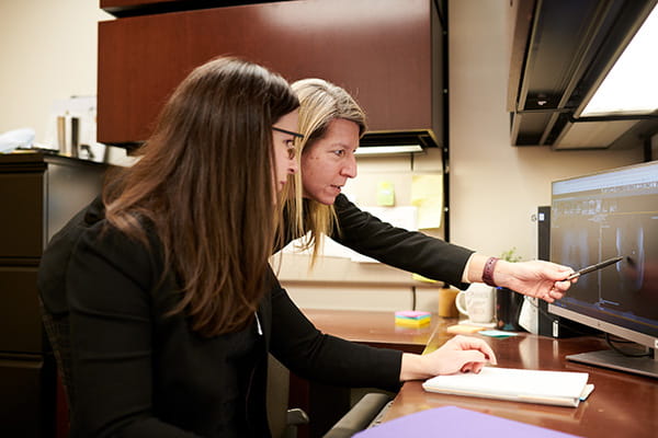 A photo of two researchers looking at images.