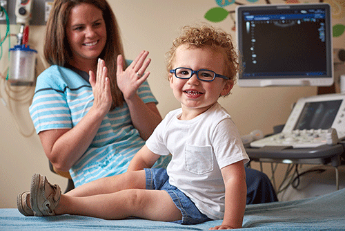 Photo of a child sitting in front of an ultrasound machine.