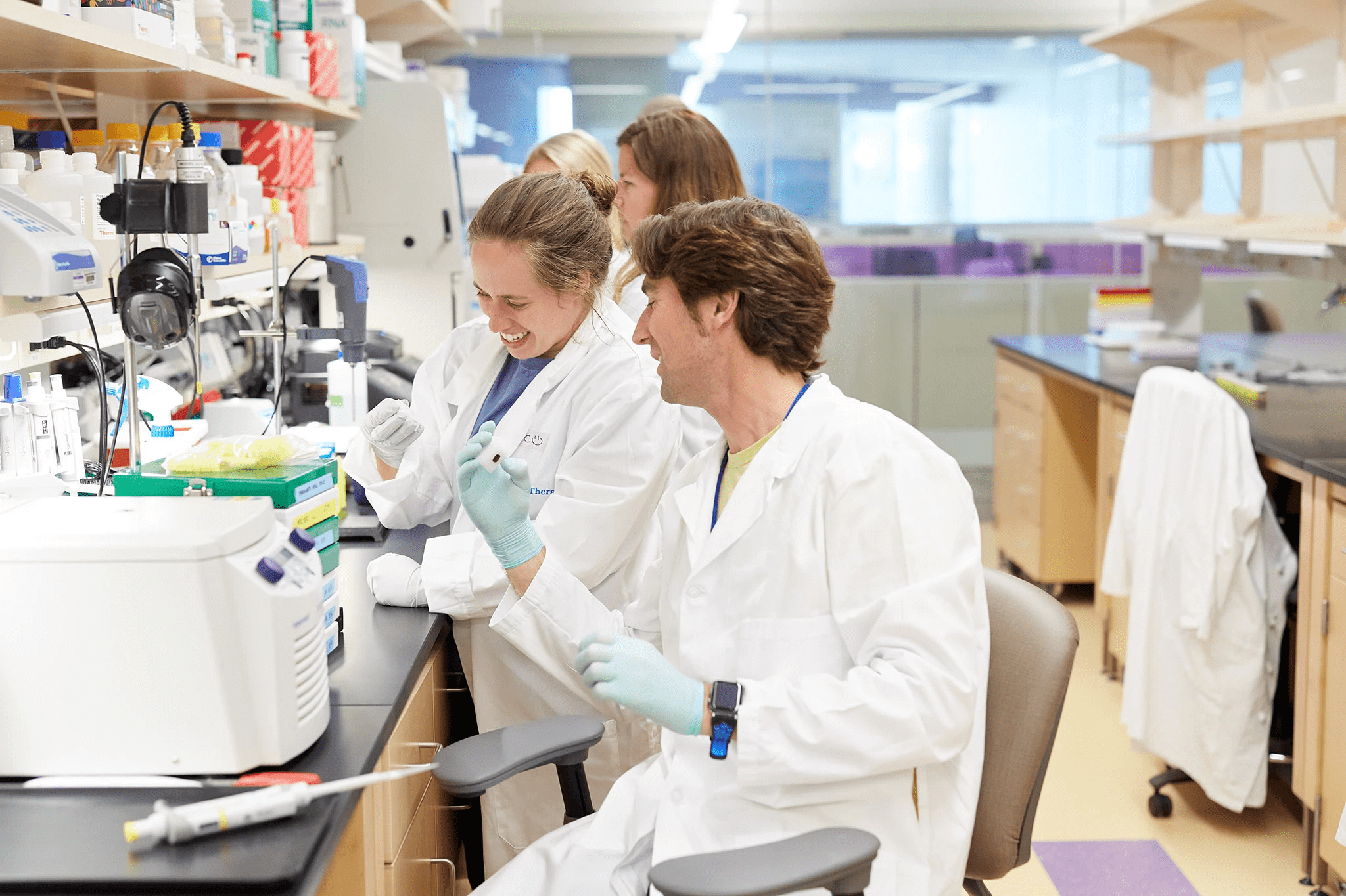 Postdoctoral researchers working together and smiling.