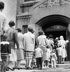 Historical photo of families lined up in 1960 to be the first to receive the oral polio vaccine.