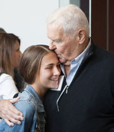 Grandfather kisses her granddaughter.