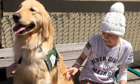 Katie pets facility dog Chevy.