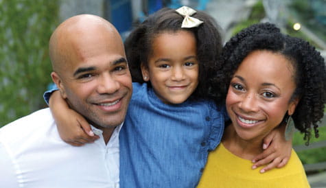 Chloe smiles with mom and dad.