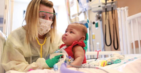 Nurse and baby in NICU.