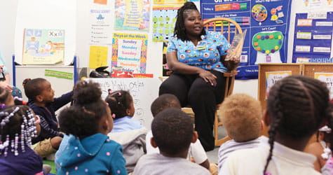 Cincinnati Children's employee reads to school children.