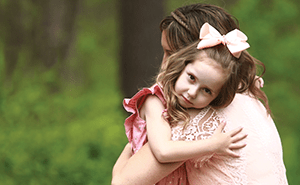 Mom and daughter hug.