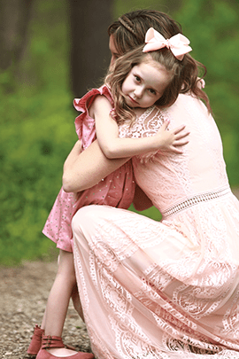 Mom hugs daughter.