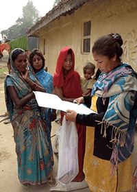 A researcher surveys villagers in Nepal.