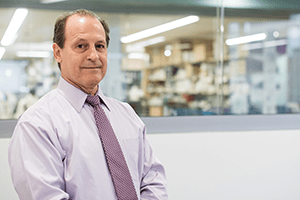 A photo of Russell Ware, MD, PhD, in front of his lab.