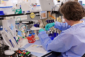 A photo of a lab technician conducting immunology testing.