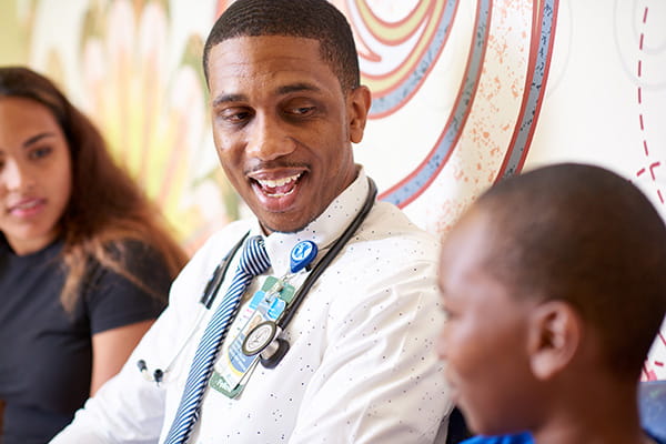 A provider sitting with two patients.