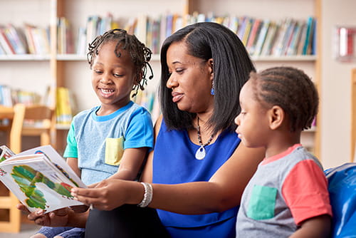 A photo of a volunteer reading to students.