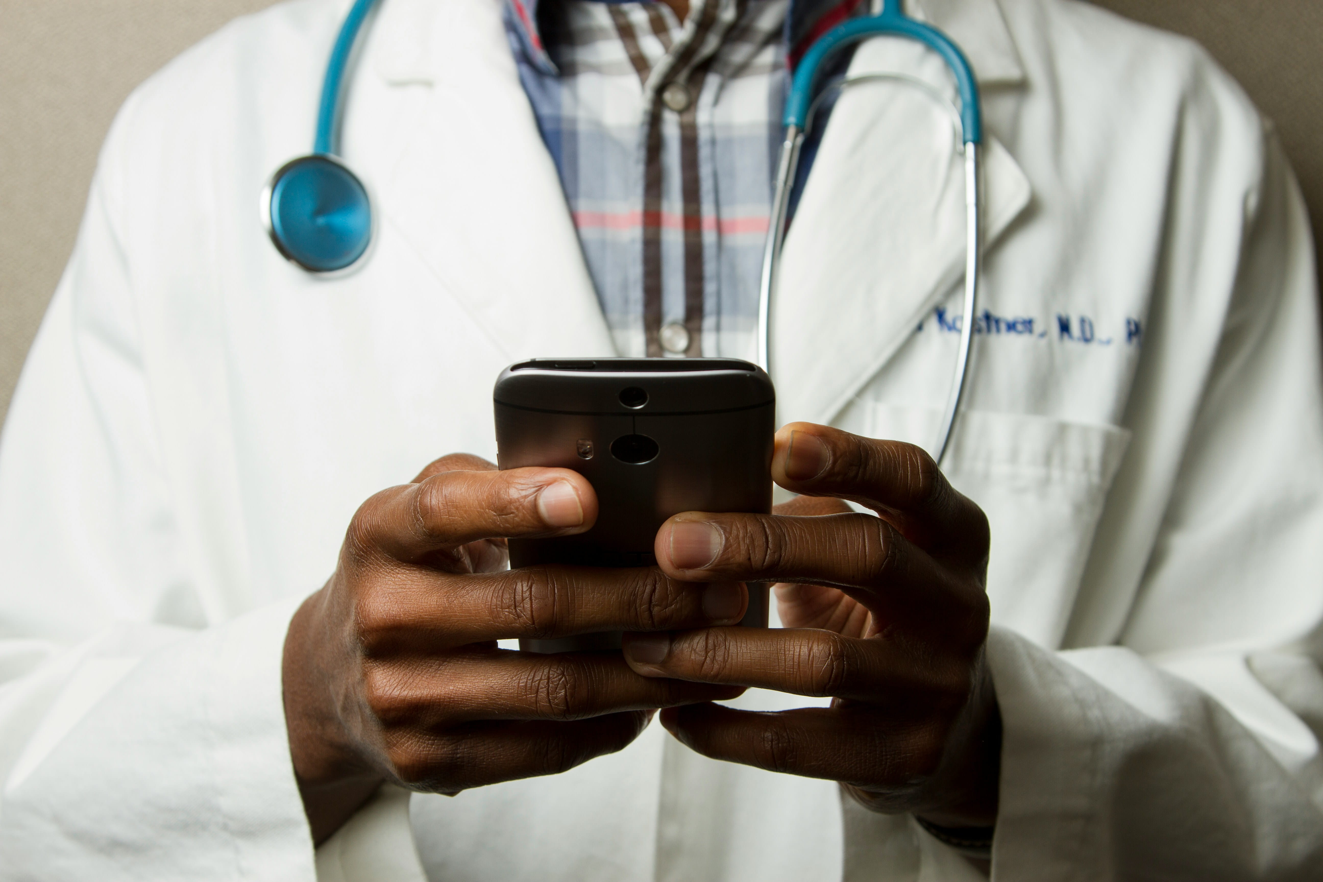 A doctors hands holding a cell phone.