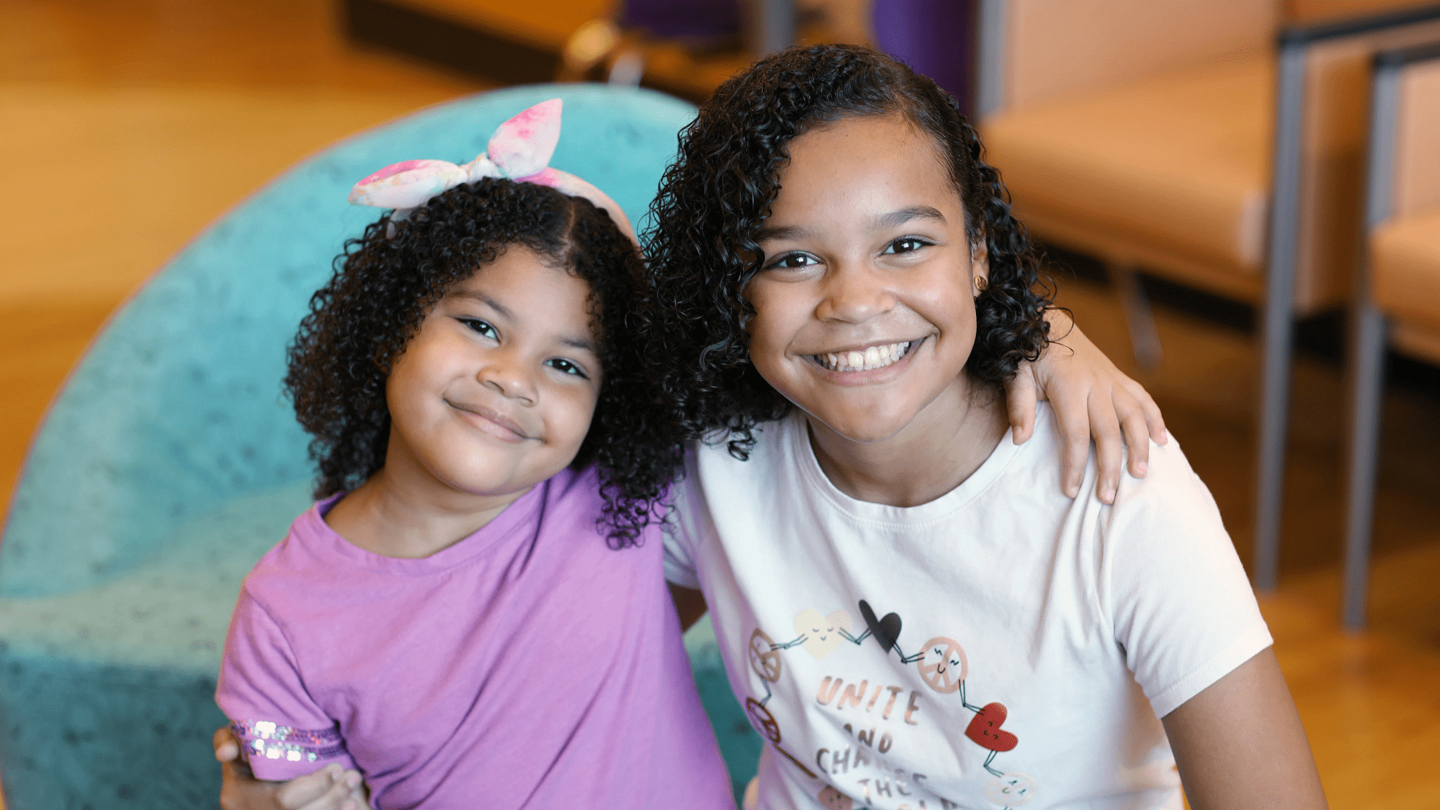 Two sisters with their arms around each other.