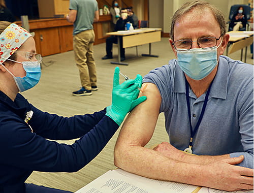 Dr. Robert Frenck of Cincinnati Children's gets a COVID-19 vaccination.