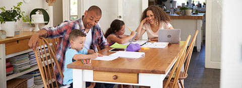 Family doing school work at the table.