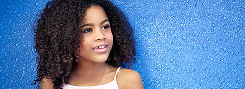 Girl in front of a blue wall.