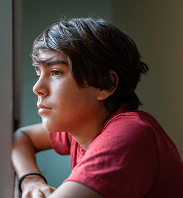 A young boy looking out the window.