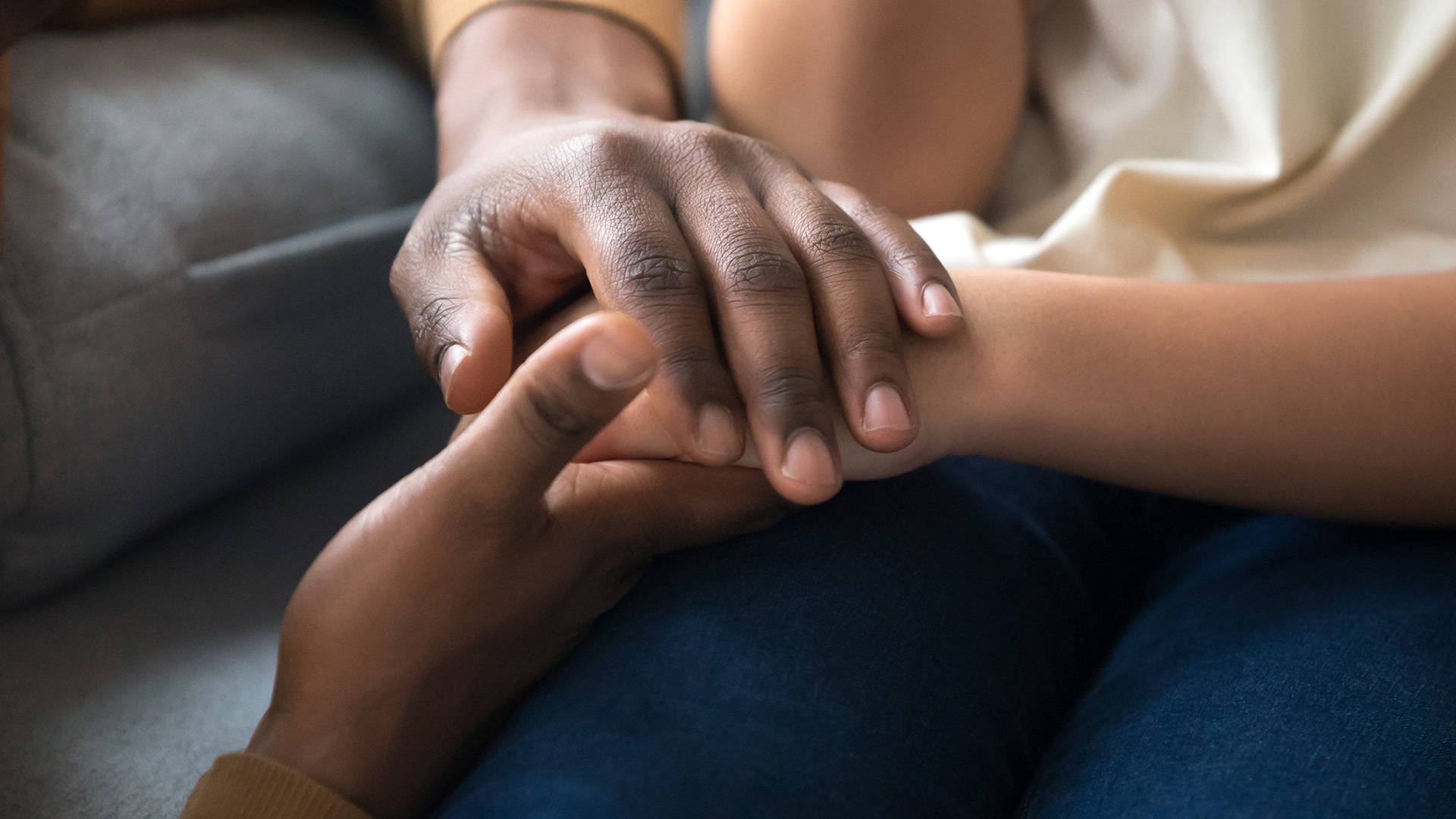 Parents holding hand of child.