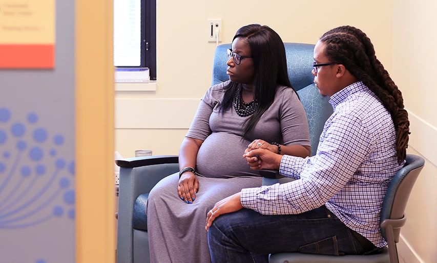 A couple sit together at an appointment.