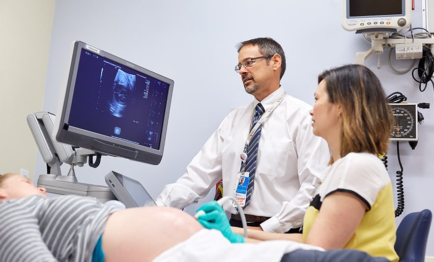 A doctor examines a pregnant patient.