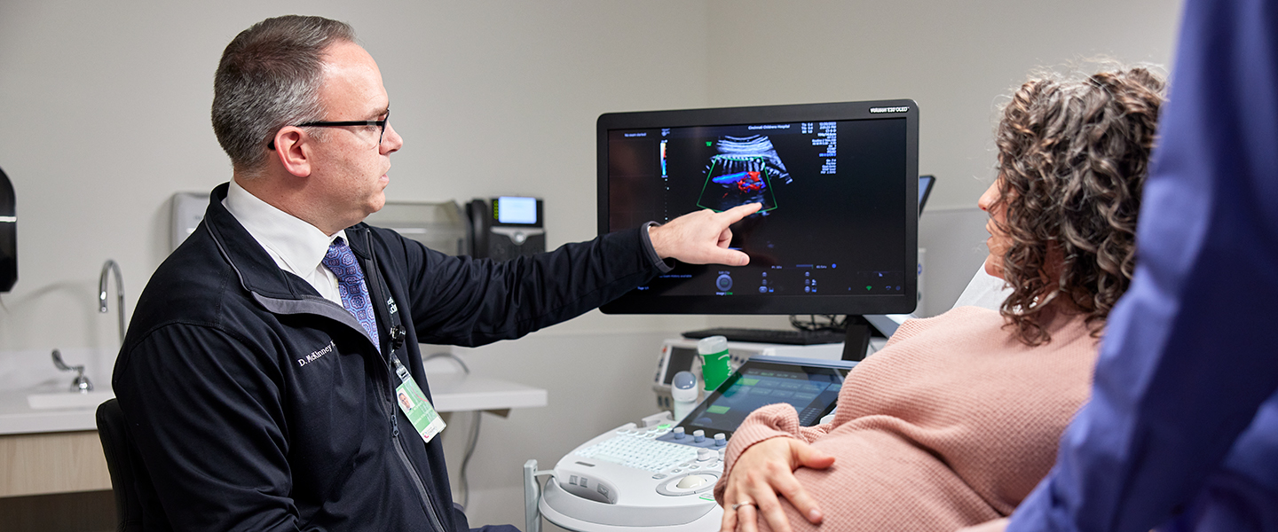 A doctor reviews imaging results with fetal care patients.