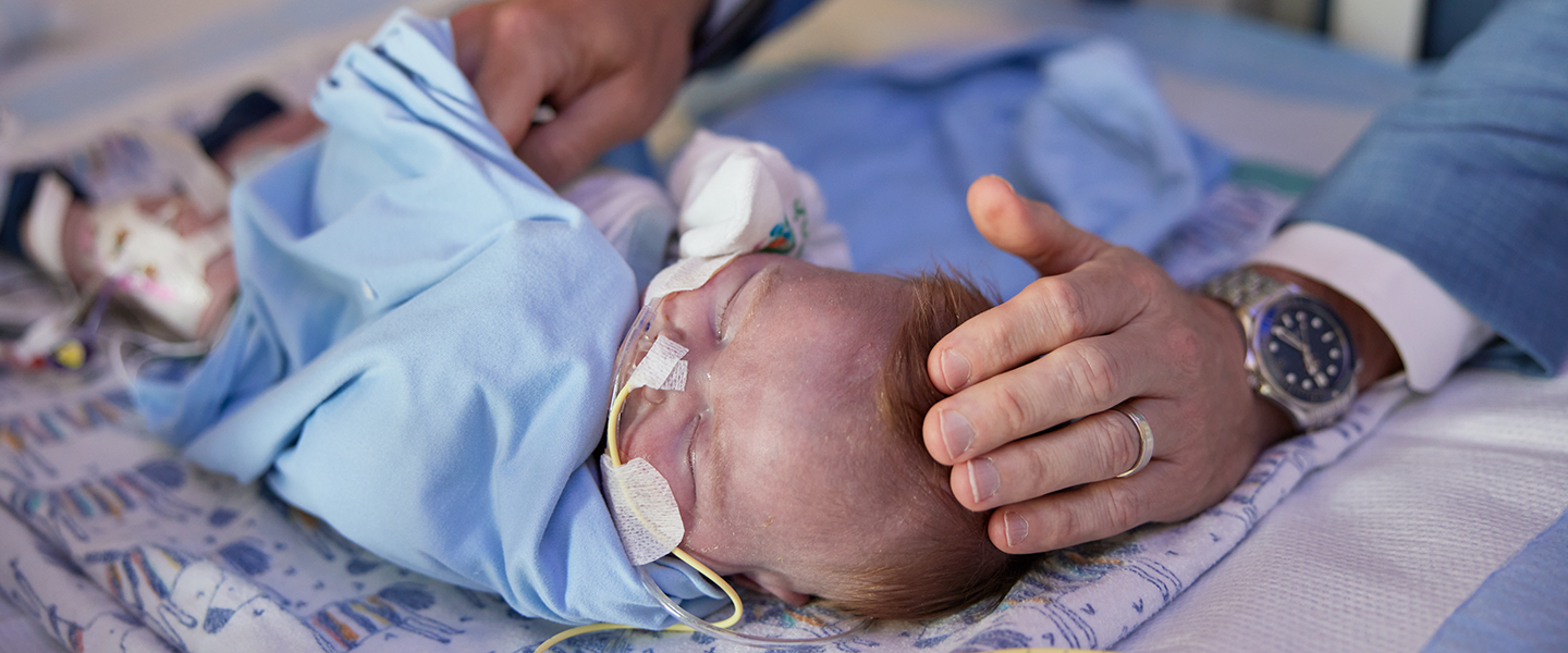 A doctor listens to an infant patient's heart with a stethoscope.