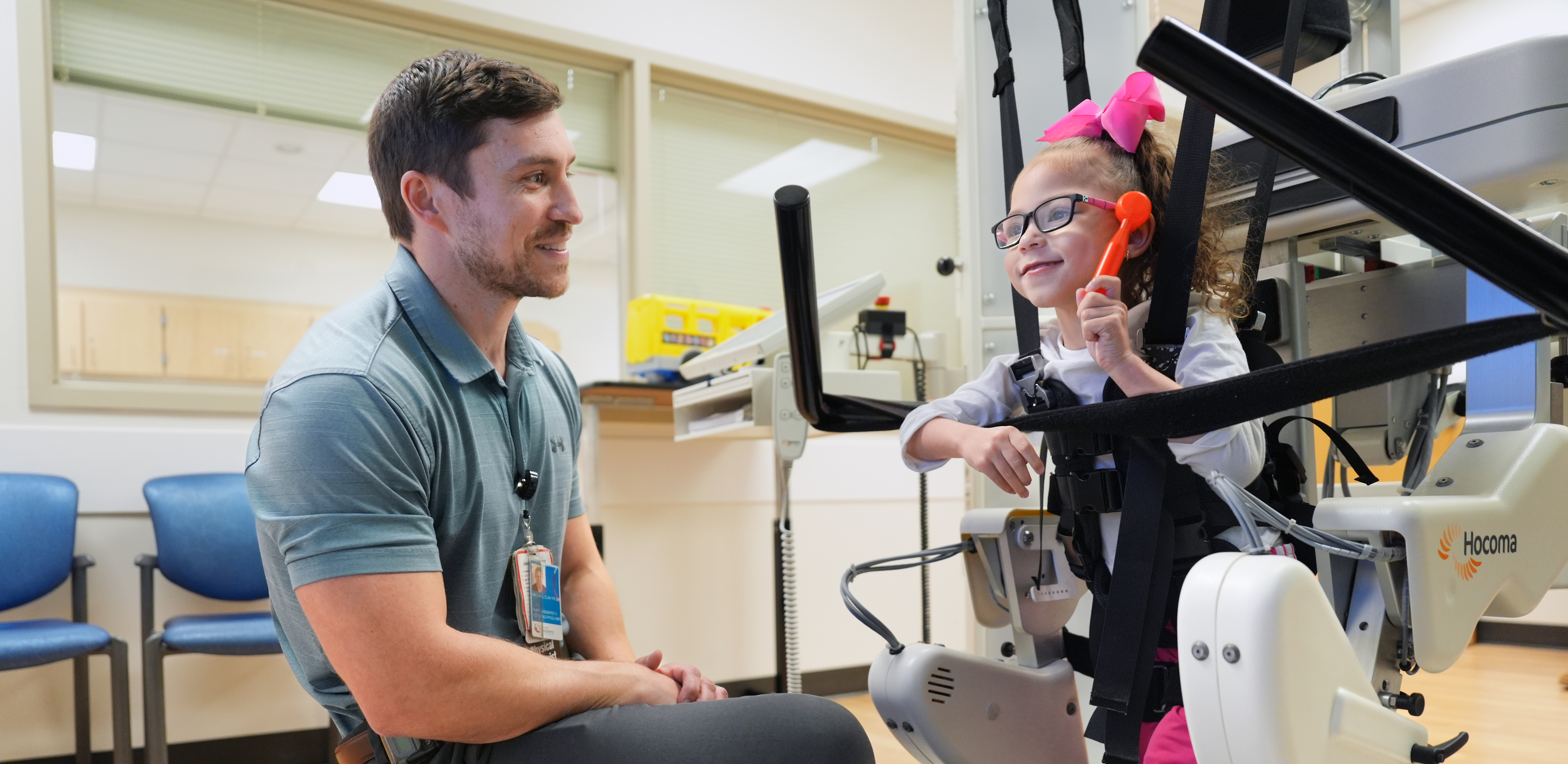 A physical therapist treats a patient using the Lokomat rehabilitation machine.