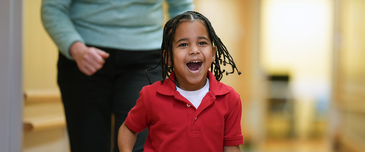 A patient walking down a hallway with a physical therapist.