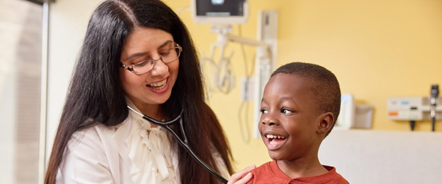 A doctor uses a stethoscope to listen to a child's breathing.