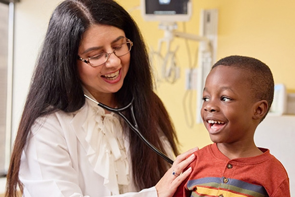 A doctor uses a stethoscope to listen to a child's breathing.