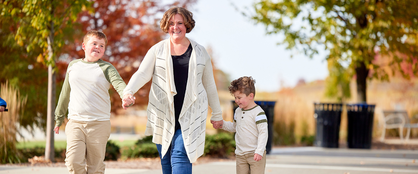 A mom walks with her two sons.