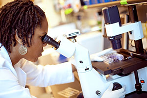A researcher using a microscope.