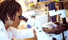 A researcher using a microscope.