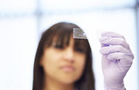 An image of a researcher looking at a microscope slide.