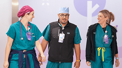 Three nurses walking together and talking.