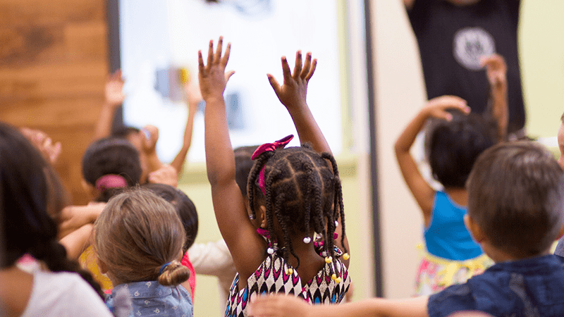 Group of four boys with their arms around each other.