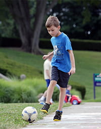 Sam kicking a ball.