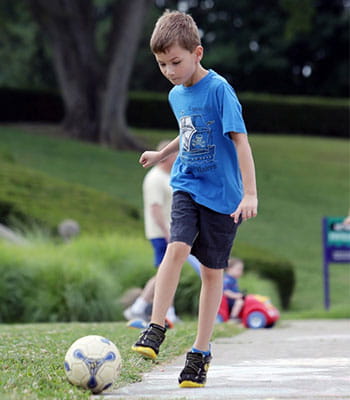 Sam is kicking a soccer ball.