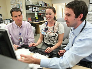 Doctors gathered at a computer.