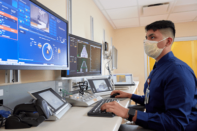 Researcher at the proton therapy center looking at data on a computer monitor.